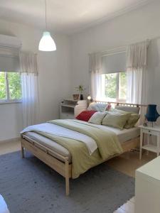een witte slaapkamer met een groot bed en ramen bij sunny 2bedroom apartment in weibdeh with a rooftop in Amman
