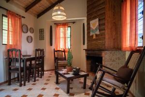 a living room with a table and chairs and a fireplace at Hotel Altocerro in Constanza