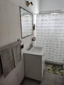 a bathroom with a sink and a shower curtain at Depto en el centro de General Roca in General Roca