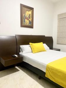 1 dormitorio con 1 cama con almohada amarilla en Hotel Palma 70, en Medellín