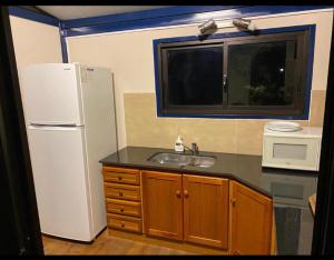 eine Küche mit einem weißen Kühlschrank und einer Spüle in der Unterkunft ONE TRIP in Paysandú