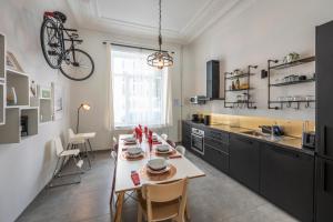 Superb 3 Bedroom & 3 Bathroom Duplex In Brussels City Centre في بروكسل: مطبخ مع طاولة ودراجة على الحائط