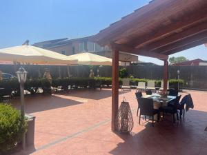 薩雷諾的住宿－B&b Villa Romano，一个带桌椅和遮阳伞的庭院