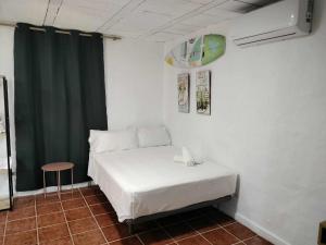 een slaapkamer met een wit bed en een groen gordijn bij Agave lujo y relax en la playa in Chiclana de la Frontera
