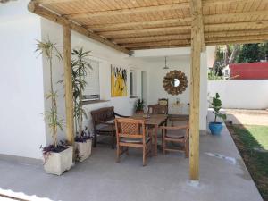 een patio met een houten pergola met een tafel en stoelen bij Agave lujo y relax en la playa in Chiclana de la Frontera