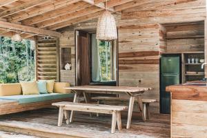 a wooden cabin with a table and a bench at Bocas Garden Lodges in Bocas del Toro
