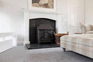 a living room with a fireplace and a couch at Two Bedroom Country Cottage With Parking in Musselburgh