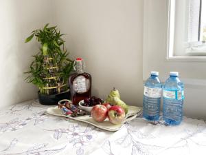 Guest suite in Richmond(Rose Garden Vacation) في ريتشموند: طاولة مع صحن من الفاكهة وزجاجات الماء