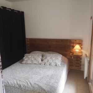 a bedroom with a bed with a wooden headboard at T 2 à 5 mn à pied de la mer in Sanary-sur-Mer