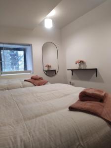 a bedroom with two beds and a mirror and a window at Spacious Two bedroom City apartment Longs Place, Dublin 8 in Dublin