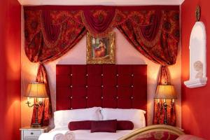um quarto vermelho com uma cama de dossel vermelho em Hotel LUX (Rouge) em Blackpool