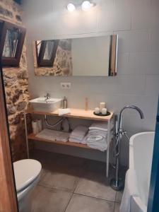 La salle de bains est pourvue d'un lavabo, d'un miroir et de toilettes. dans l'établissement La Gavina, à Beáriz