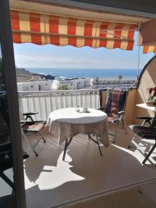 a table and chairs on a balcony with an umbrella at Callao Sun & Pool II in Callao Salvaje