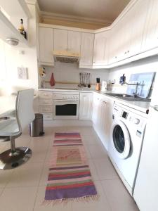 a white kitchen with a washing machine and a sink at Callao Sun & Pool II in Callao Salvaje