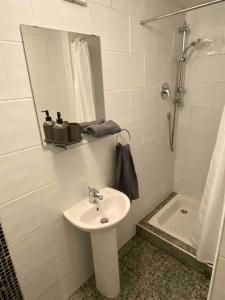 bagno bianco con lavandino e specchio di City centre house close to 3 Arena a Dublino