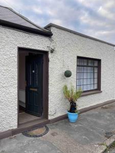 una casa blanca con una puerta y una maceta en City centre house close to 3 Arena en Dublín