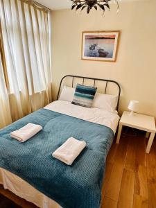 a bedroom with a bed with two towels on it at London Mackenzie Suites in London