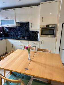 a kitchen with a wooden table with a vase of flowers on it at London Mackenzie Suites in London