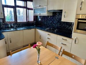 a kitchen with a table with a vase of flowers on it at London Mackenzie Suites in London