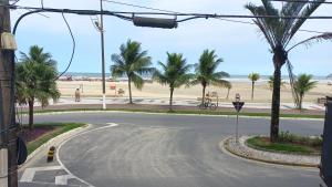 eine leere Straße mit Palmen und Strand in der Unterkunft Apto 414- Prédio em frente da praia in Praia Grande