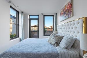 a bedroom with a king sized bed with windows at Unique 3BR in NYC in New York