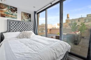 a bedroom with a bed and a large window at Unique 3BR in NYC in New York
