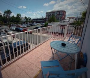 einen Balkon mit einem Tisch und Stühlen sowie einen Parkplatz in der Unterkunft Urban Lodgings Two @ Roosevelt 457 in San Juan