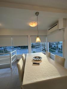 a dining room with a table with white chairs and a large window at MAILAR d1 in Puerto Madryn