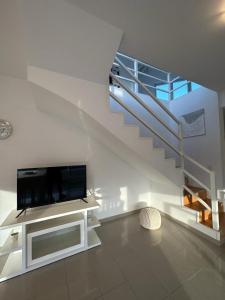 a living room with a tv and a staircase at MAILAR d1 in Puerto Madryn