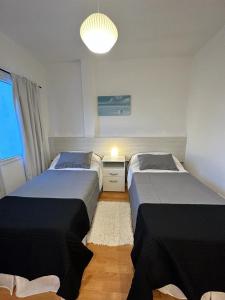 1 Schlafzimmer mit 2 Betten und einem Kronleuchter in der Unterkunft MAILAR d1 in Puerto Madryn