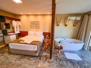 a hotel room with a bed and a bath tub at Pousada Noah Noah in São Miguel dos Milagres