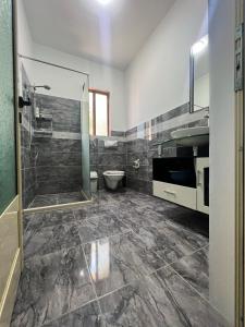 uma casa de banho com um chuveiro, um WC e um lavatório. em Villa Kanto (Holiday apartments and rooms) em Vlorë