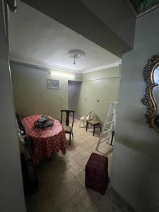 um quarto com uma mesa e cadeiras e um quarto com um espelho em شقة مصيف قريبة للبحر في ميامي em Alexandria