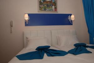 a bed with two blue pillows on top of it at Mavi Inci Park Otel in Erdek