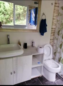 a bathroom with a toilet and a sink and a window at Finca de recreo Claro de Luna in Copacabana