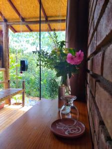 Casa Raízes Capão في فالي دو كاباو: إناء من الزهور على طاولة خشبية