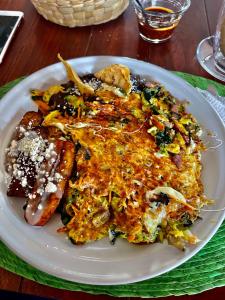 a plate of food with sausage and other food on a table at Hotel casa teresa café galería in Juchitán de Zaragoza +23 photos