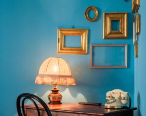 stół z lampką na niebieskiej ścianie w obiekcie Fabula Rooms 3 Suites with private bathroom w Bolonii