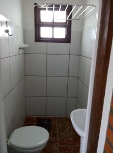 a bathroom with a toilet and a sink at Apartamentos Apiaí in Ilha Comprida