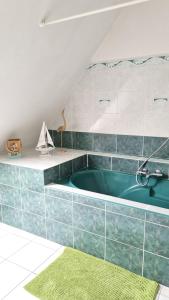 a bathroom with a green tub in a attic at Maison de 4 chambres avec jardin clos et wifi a Tregomeur a 8 km de la plage in Trégomeur