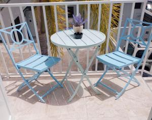 two blue chairs and a table with a plant on a porch at Urban Lodgings Two @ Roosevelt 457 in San Juan