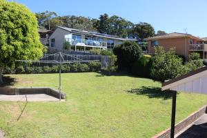 a yard with a basketball hoop in front of a house at The Views - 3 or 4 Bedroom in Tura Beach