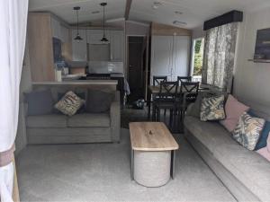 a living room and kitchen with a couch and a table at Luxury caravan in Porthmadog