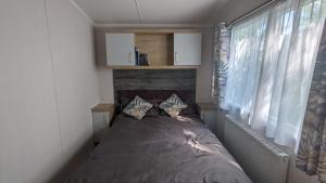 a small bedroom with a bed in a room at Luxury caravan in Porthmadog