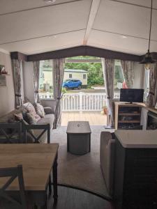 a living room with a couch and a table at Luxury caravan in Porthmadog