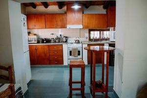 a kitchen with wooden cabinets and a table in it at Huaco Casa de Campo in Belén +32 photos