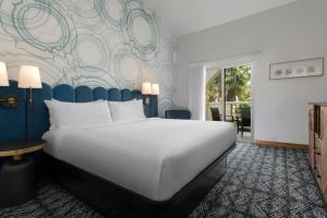 a bedroom with a large white bed and a wall mural at Catalina Canyon Inn in Avalon +20 photos