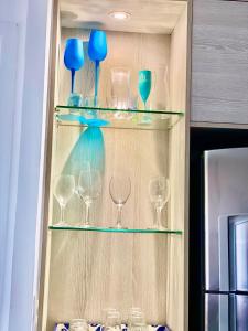 a shelf filled with glasses and blue vases at Landscape Beira Mar Deluxe Vista Mar in Fortaleza