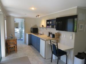 a kitchen with a counter and a table and chairs at Wildferns Lodge and Sailors Studio Opua in Opua