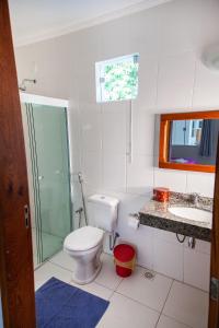 a bathroom with a toilet and a shower and a sink at Mansão Residence & Club in Vassouras